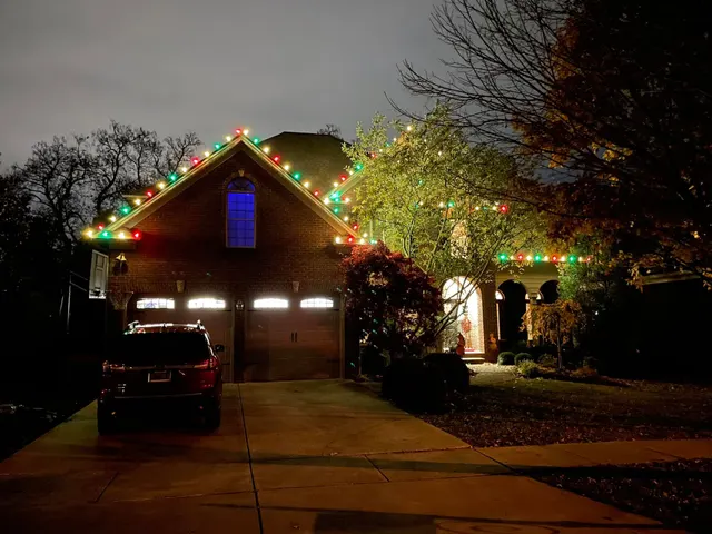 Multicolored Christmas lights outlining a home and garage