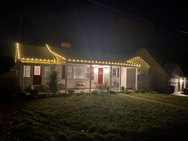 Warm Christmas lights tracing a home roofline and front porch