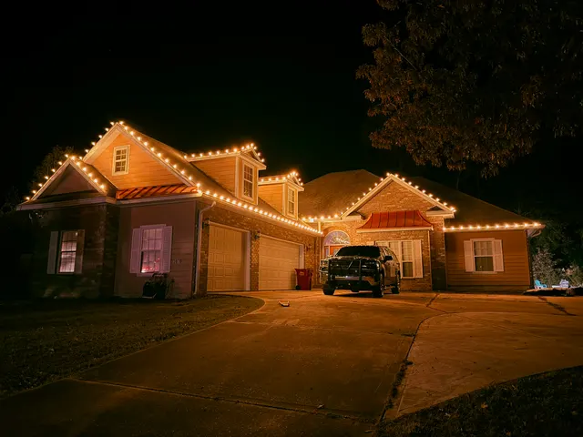 Warm Christmas lights outlining the roof of a brick home