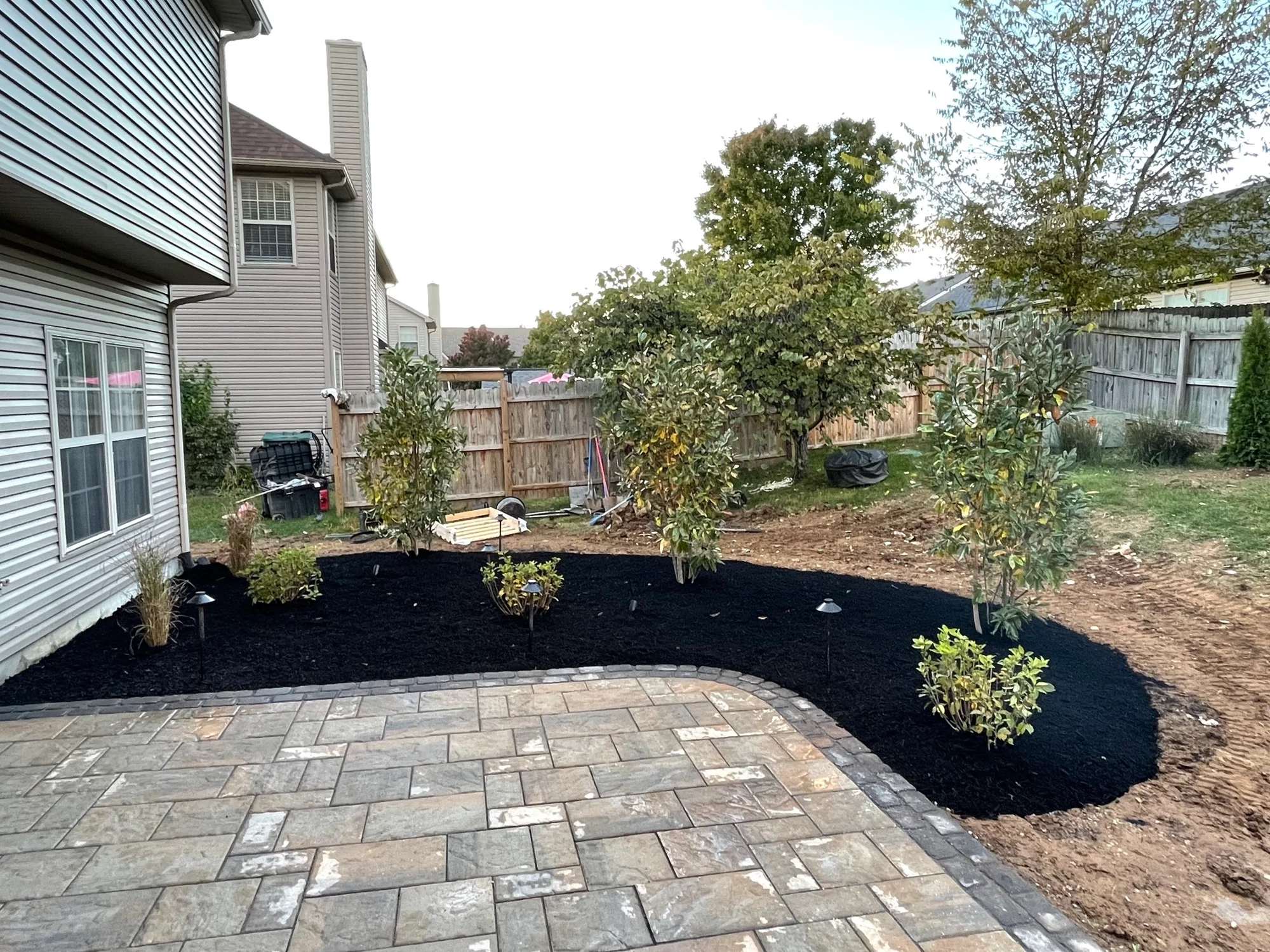 Curved planting bed bordering a paver patio