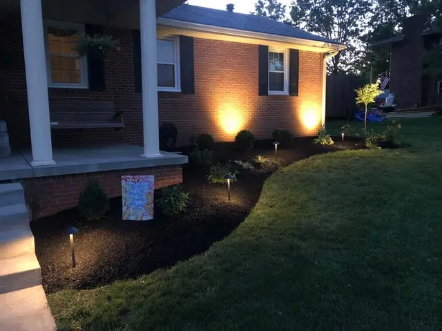 Landscape lighting highlighting a brick entry and planting bed