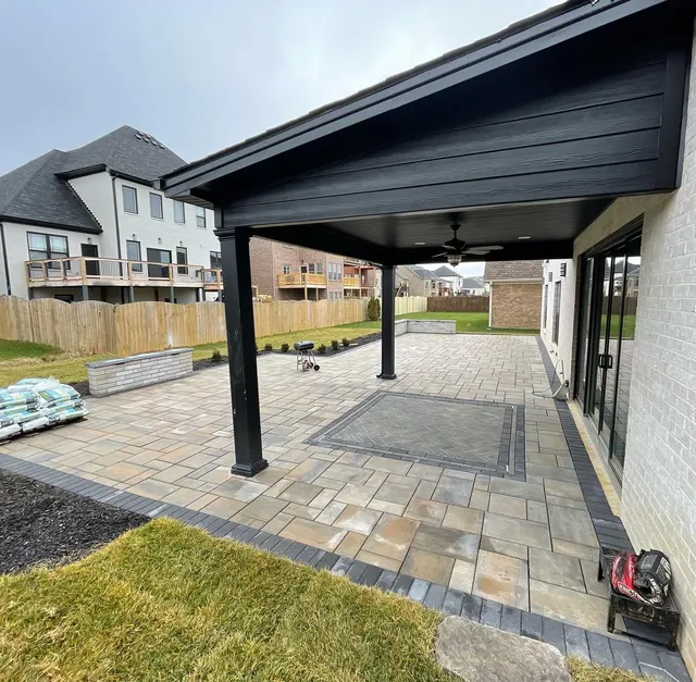 Paver patio with a dark border beneath a covered outdoor space