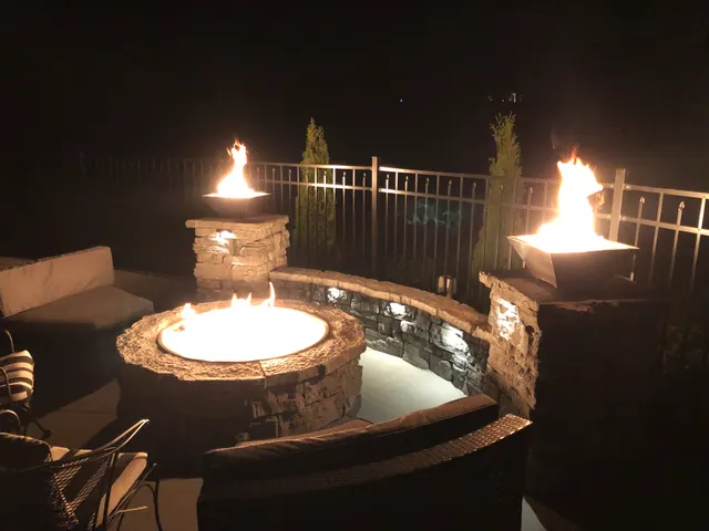 Circular outdoor fire feature and masonry columns at night