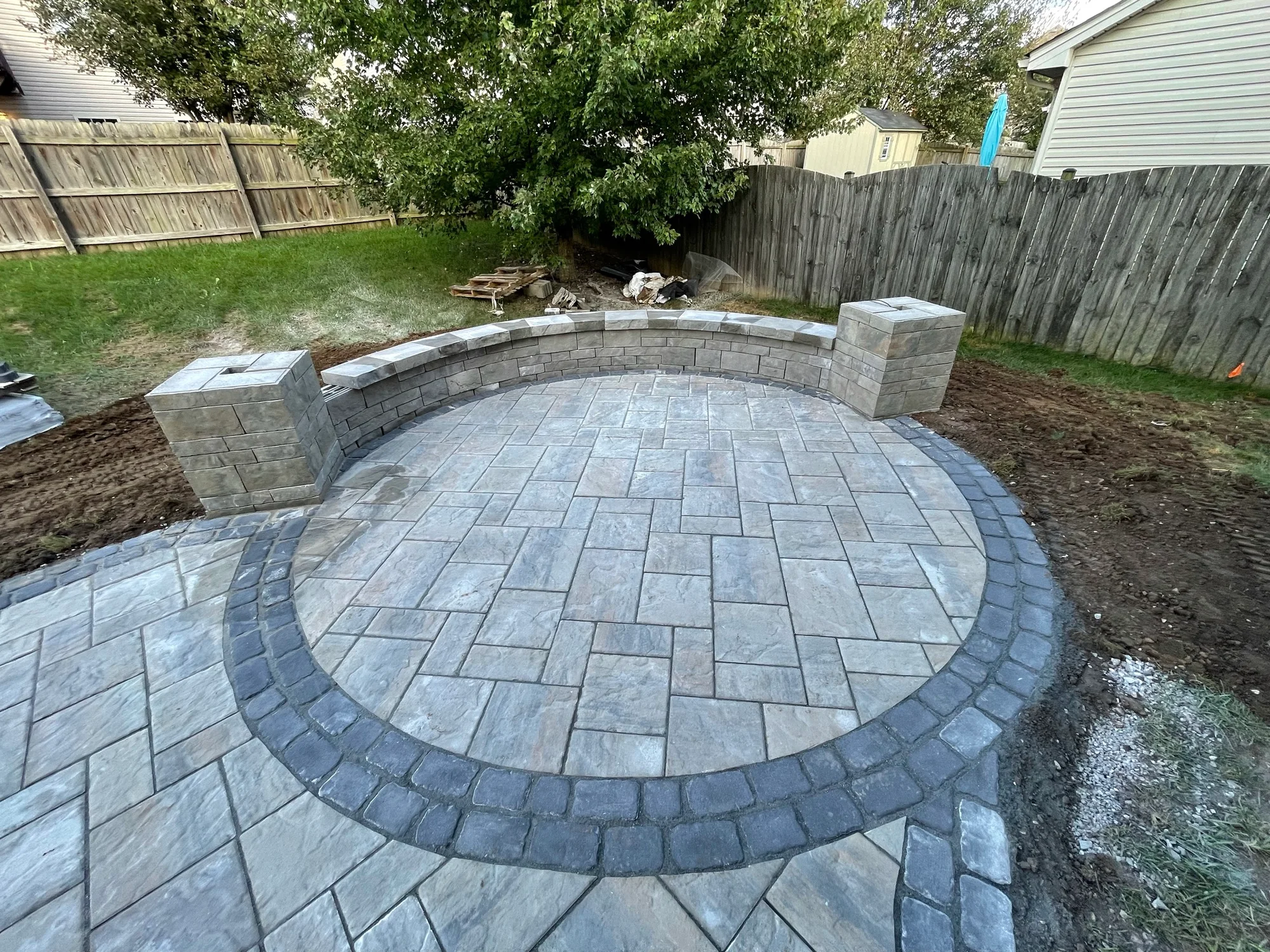 Circular paver inset with a curved seating wall and columns