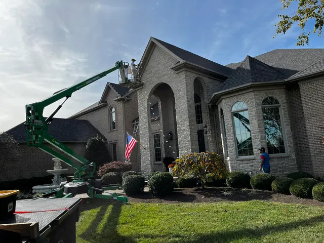 Crew using a lift to work along a home roofline