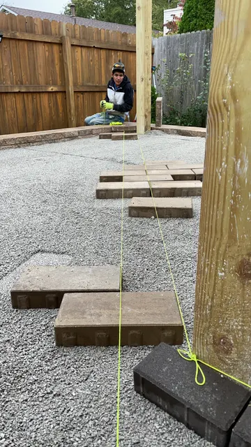 Prepared patio base and pavers staged for installation
