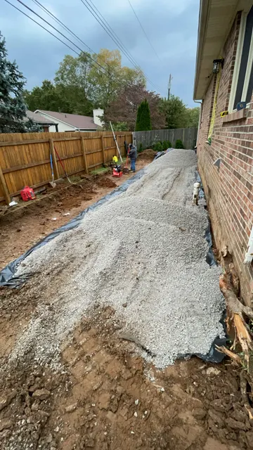 Gravel base preparation beside a brick home