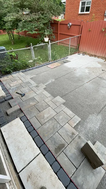 Pavers being fitted around a patio step