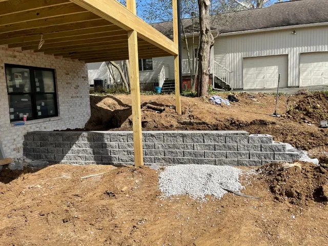 Block retaining wall installation beneath an elevated deck